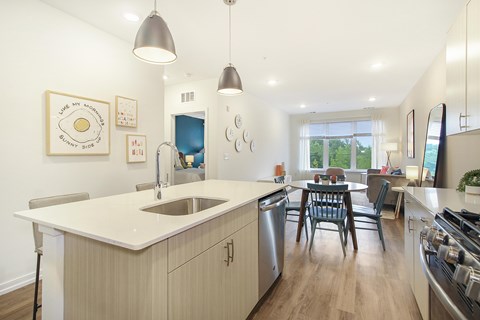 A modern kitchen with a large island and pendant lights.